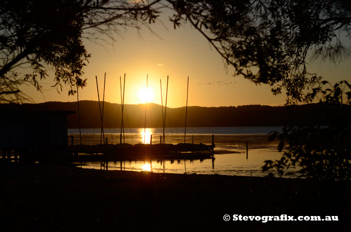 Sunet over boat sheds Long Jetty